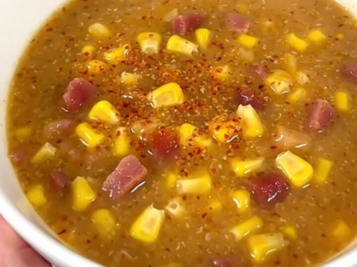 A steaming bowl of creamy chipotle bacon corn chowder garnished with crispy bacon bits.
