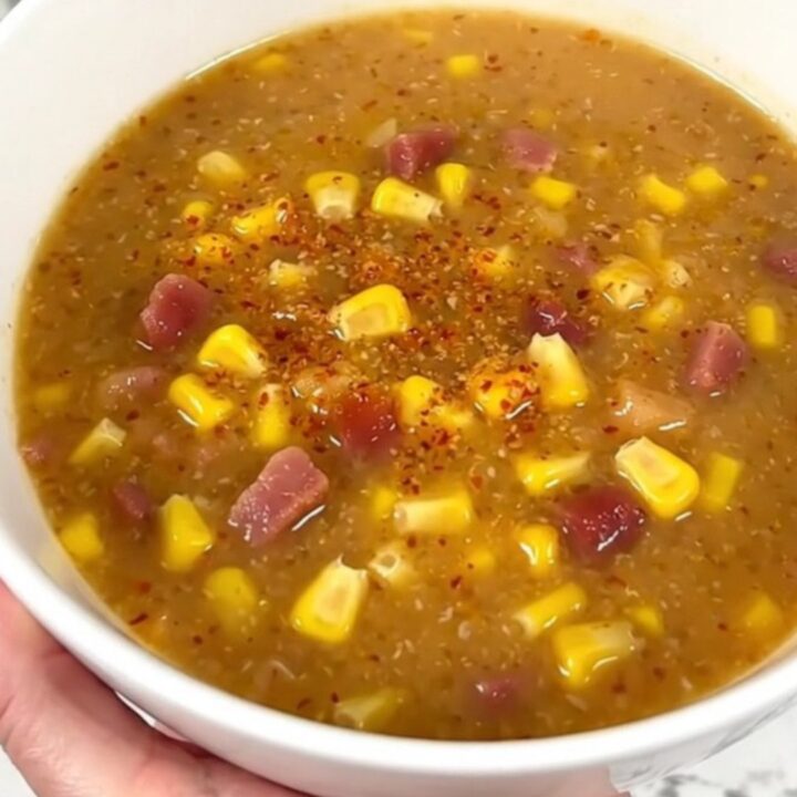 A steaming bowl of creamy chipotle bacon corn chowder garnished with crispy bacon bits.