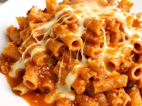 A close-up of creamy buffalo ranch ziti in a black slow cooker on a white countertop.