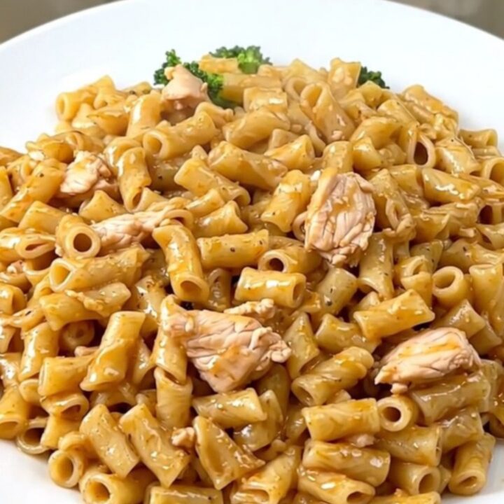 A top-down view of a slow cooker filled with chicken, broccoli, and alfredo sauce ready for cooking.