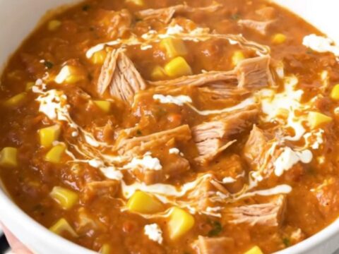 A bowl of creamy turkey and corn chili with a glossy, rich texture served in a white bowl.