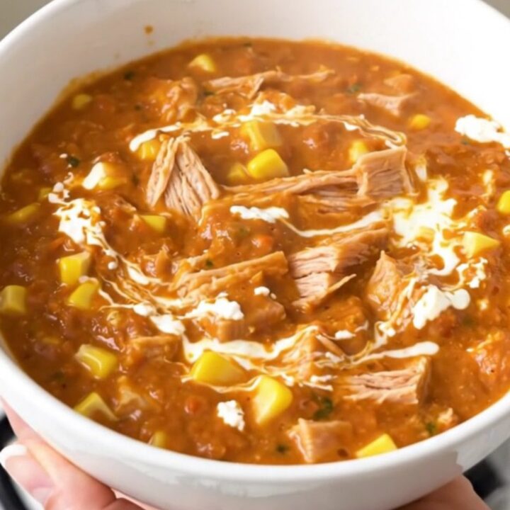 A bowl of creamy turkey and corn chili with a glossy, rich texture served in a white bowl.
