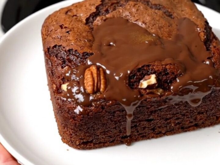 A rich German chocolate dump cake in a slow cooker topped with coconut and pecans.