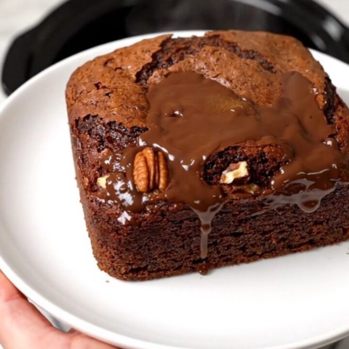 A rich German chocolate dump cake in a slow cooker topped with coconut and pecans.