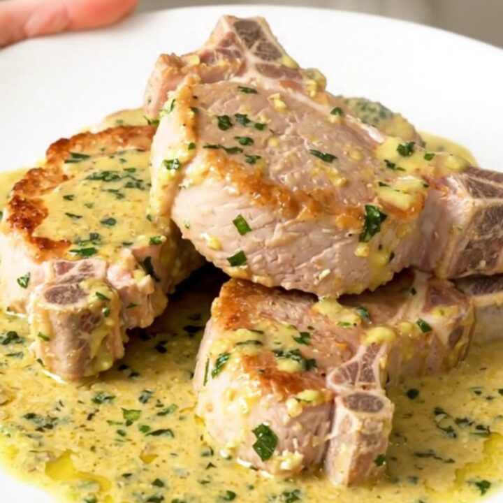 Creamy slow cooker pork chops with sliced mushrooms in a white bowl
