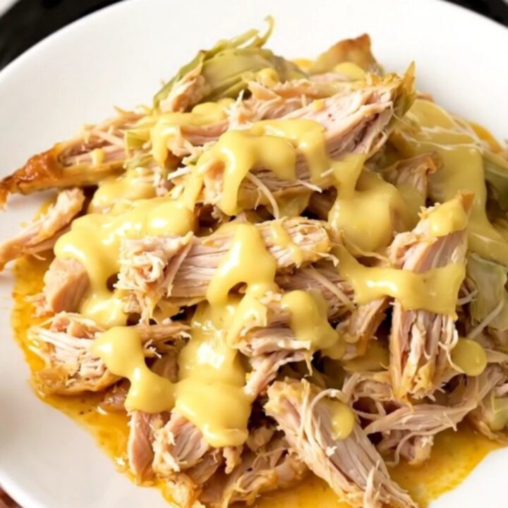 Slow cooker filled with creamy chicken and artichoke hearts.