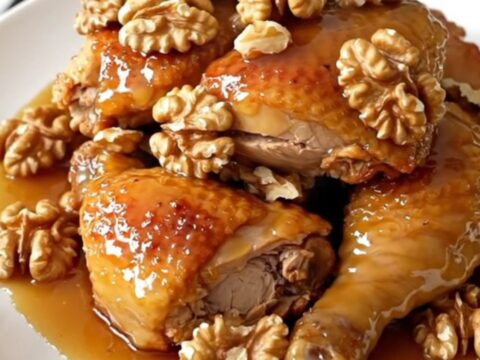 A close-up of glossy honey walnut chicken served on a white plate.