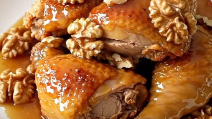 A close-up of glossy honey walnut chicken served on a white plate.