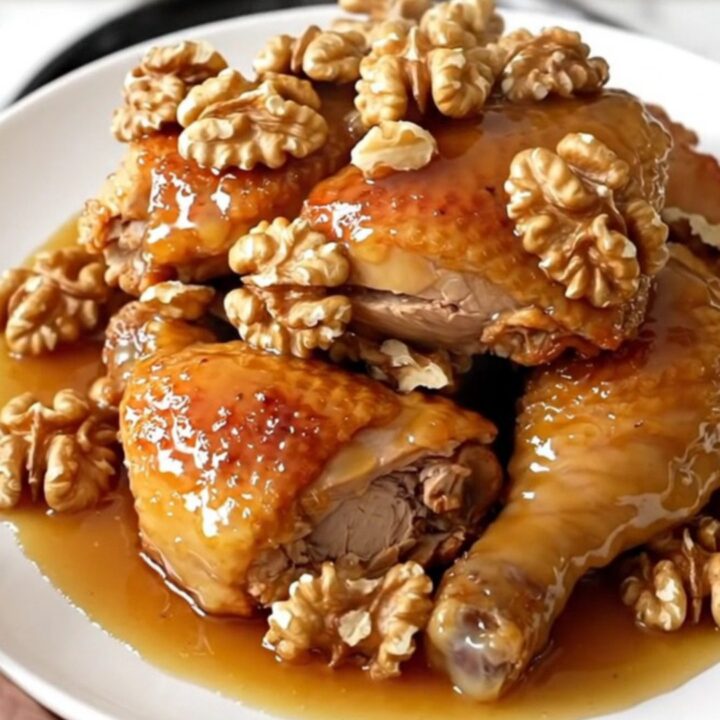 A close-up of glossy honey walnut chicken served on a white plate.