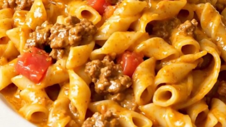 A close-up of creamy taco pasta served on a white plate with a warm, inviting atmosphere.