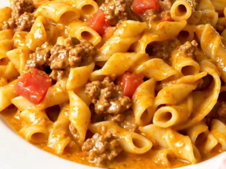A close-up of creamy taco pasta served on a white plate with a warm, inviting atmosphere.