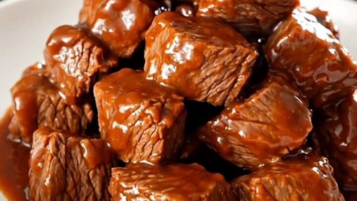 A plate of tender, glossy buffalo ranch steak bites steaming on a white plate.