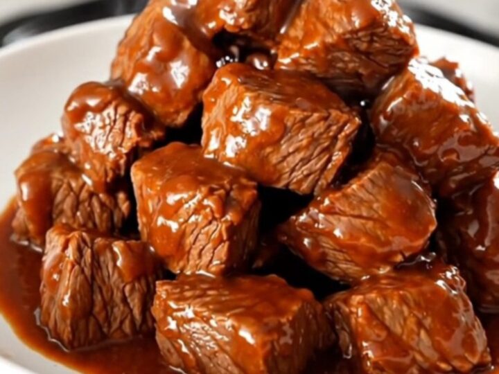 A plate of tender, glossy buffalo ranch steak bites steaming on a white plate.