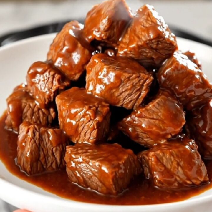 A plate of tender, glossy buffalo ranch steak bites steaming on a white plate.