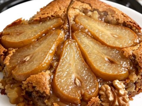 Warm spiced pear and walnut dump cake in a black slow cooker, showcasing a golden, buttery topping.