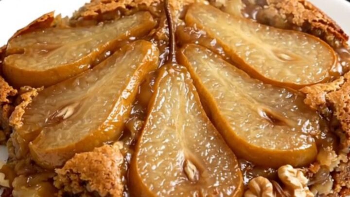 Warm spiced pear and walnut dump cake in a black slow cooker, showcasing a golden, buttery topping.