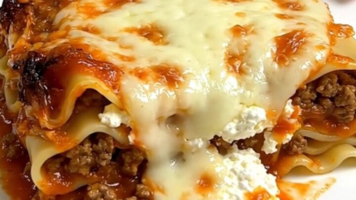 A steaming, hearty serving of ground beef lasagna in a slow cooker on a bright kitchen counter.