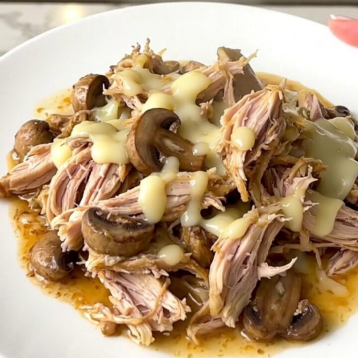 Creamy mushroom gruyere chicken served in a white bowl with a rich, glossy sauce.