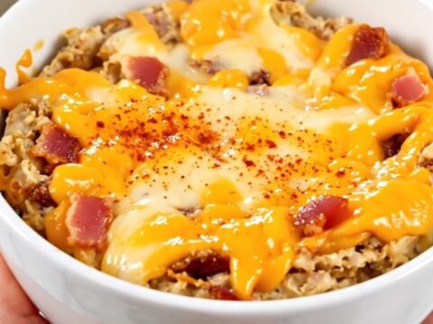 A warm, creamy smoked gouda and bacon dip served in a white bowl with toasted bread.
