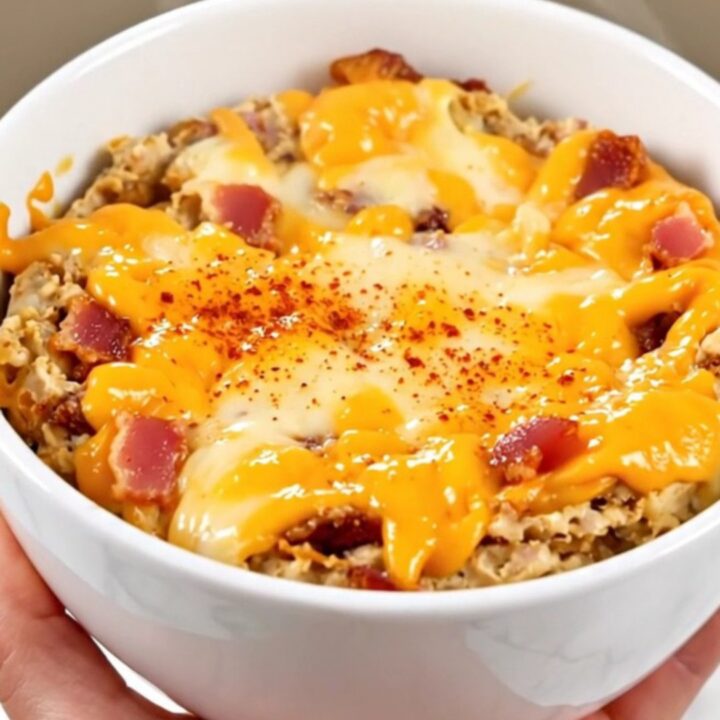 A warm, creamy smoked gouda and bacon dip served in a white bowl with toasted bread.