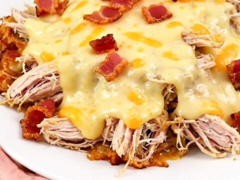 A slow cooker filled with creamy shredded chicken, bacon, and melted muenster cheese.