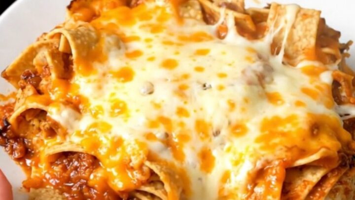 A steaming, savory slow cooker chicken tortilla casserole served on a white plate.