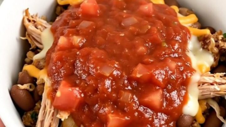 A steaming, flavorful ground turkey burrito bowl in a white bowl, showing beans and savory sauce.