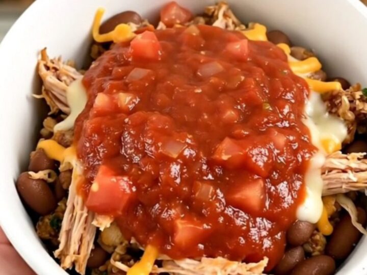 A steaming, flavorful ground turkey burrito bowl in a white bowl, showing beans and savory sauce.