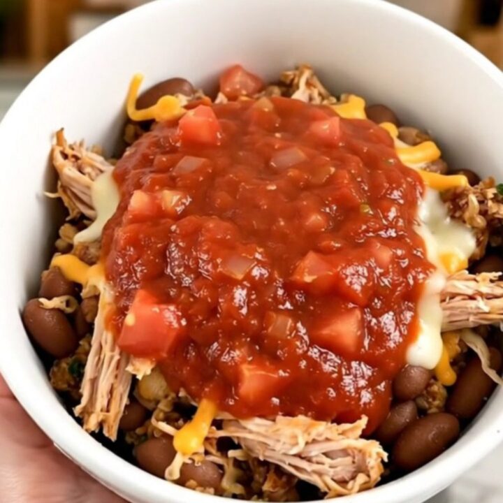 A steaming, flavorful ground turkey burrito bowl in a white bowl, showing beans and savory sauce.