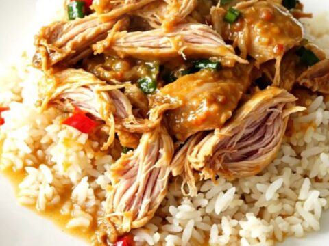 Slow cooker filled with Thai coconut lime chicken, red bell peppers, and a creamy yellow curry sauce.