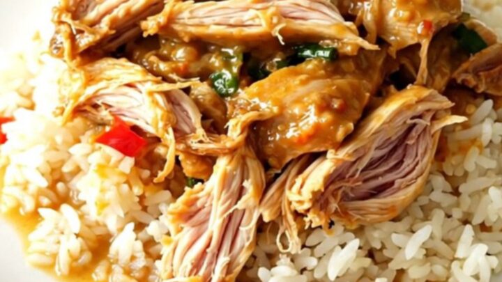 Slow cooker filled with Thai coconut lime chicken, red bell peppers, and a creamy yellow curry sauce.