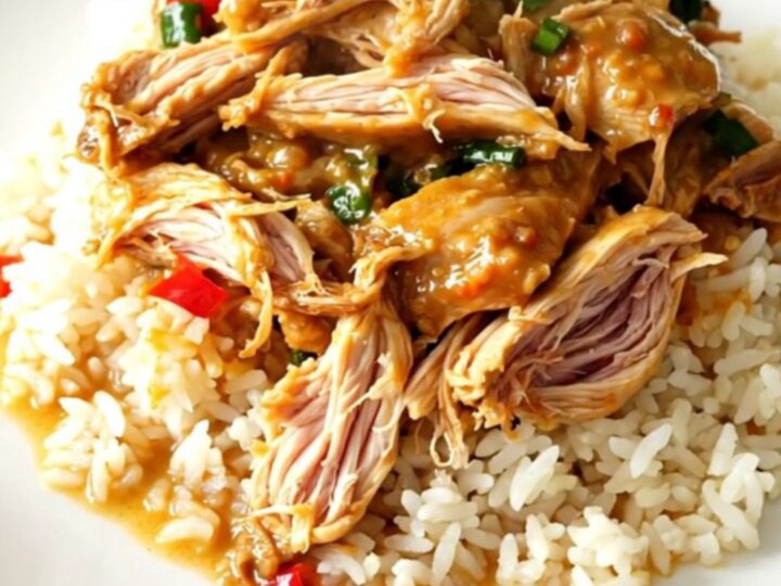 Slow cooker filled with Thai coconut lime chicken, red bell peppers, and a creamy yellow curry sauce.