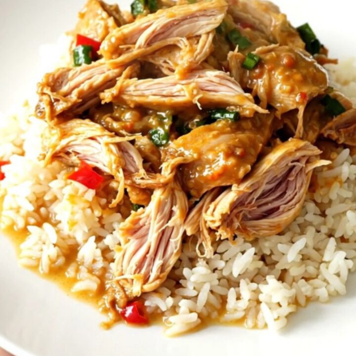 Slow cooker filled with Thai coconut lime chicken, red bell peppers, and a creamy yellow curry sauce.