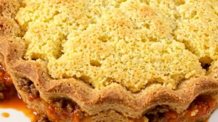 A finished Texas tamale pie served in a slow cooker, showing a golden brown cornbread crust on top of a savory beef and corn