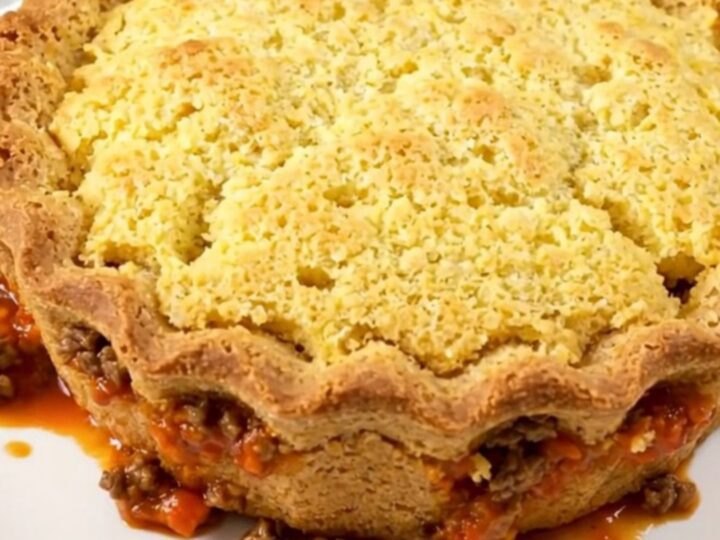 A finished Texas tamale pie served in a slow cooker, showing a golden brown cornbread crust on top of a savory beef and corn