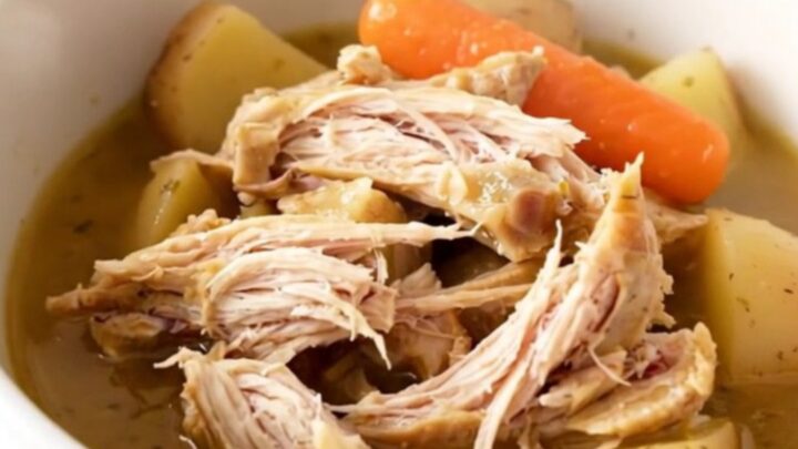 A close-up view of a bowl of slow cooker chicken stew with vegetables in a savory broth.
