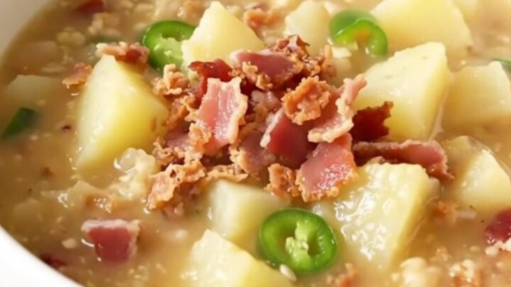 A steaming bowl of creamy potato chowder with visible pieces of bacon and jalapeno.