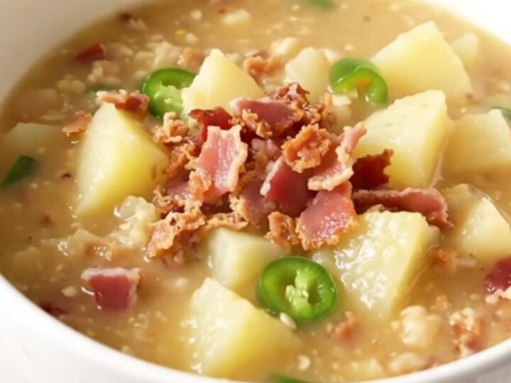 A steaming bowl of creamy potato chowder with visible pieces of bacon and jalapeno.