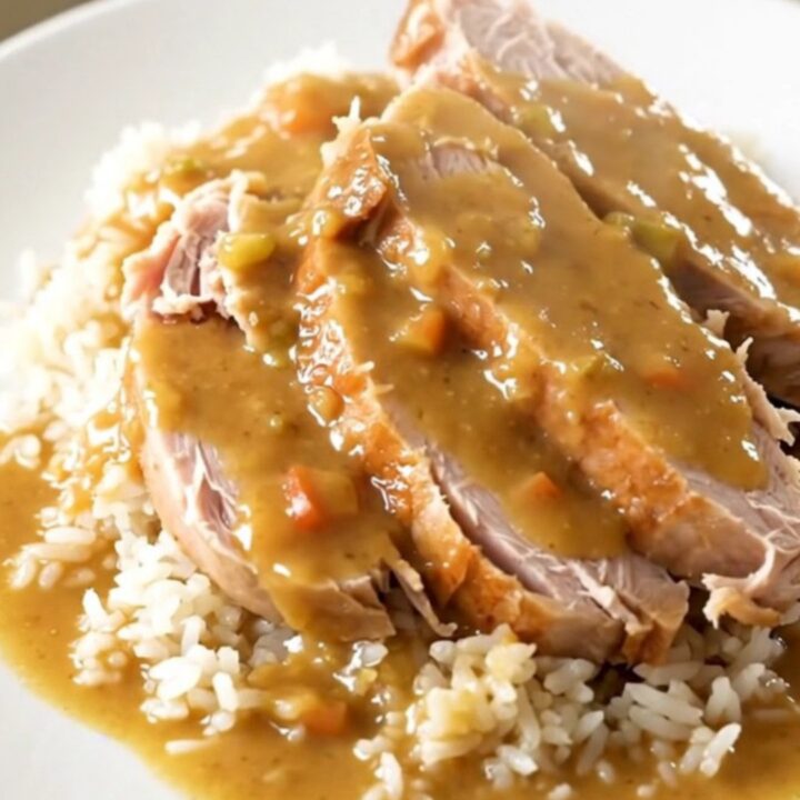 A close-up shot of creamy ranch turkey tenderloin served over white rice with tender carrots.