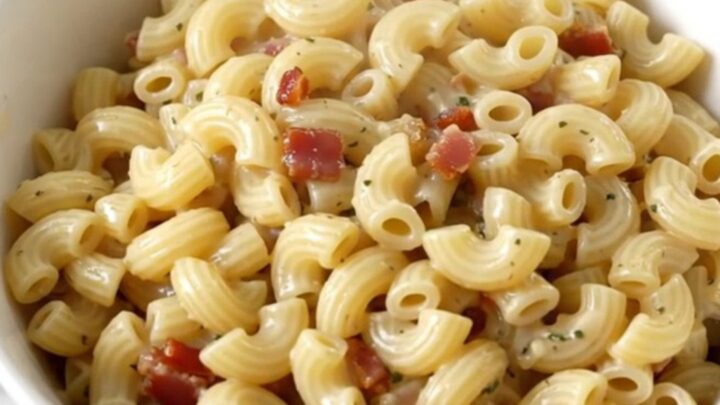 A top-down view of creamy garlic parmesan macaroni with bacon in a slow cooker.