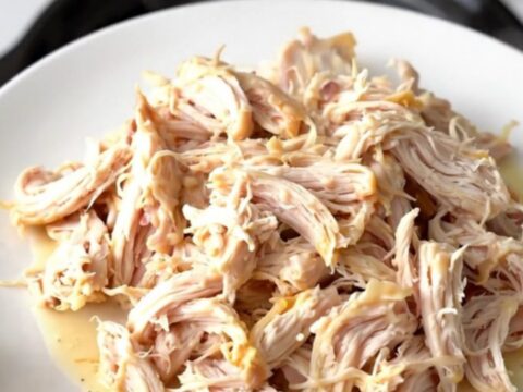 Creamy garlic white cheddar chicken served on a white plate with a steaming sauce.