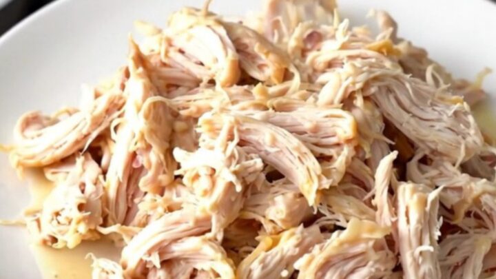 Creamy garlic white cheddar chicken served on a white plate with a steaming sauce.