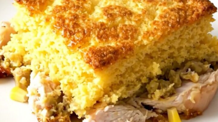 A steaming, golden-topped Crockpot Cheesy Southwestern Cornbread Chicken served in a rustic slow cooker on a bright kitchen