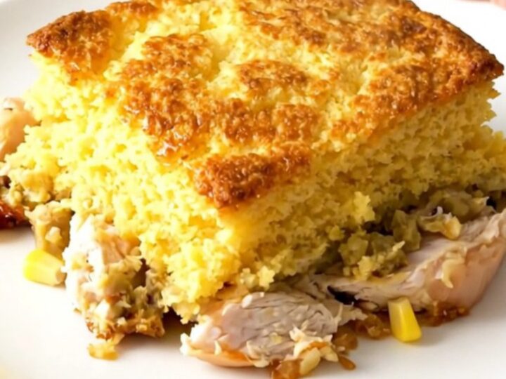 A steaming, golden-topped Crockpot Cheesy Southwestern Cornbread Chicken served in a rustic slow cooker on a bright kitchen