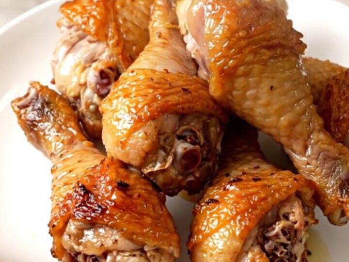 A top-down view of raw chicken drumsticks, diced celery, and ranch seasoning in a slow cooker.