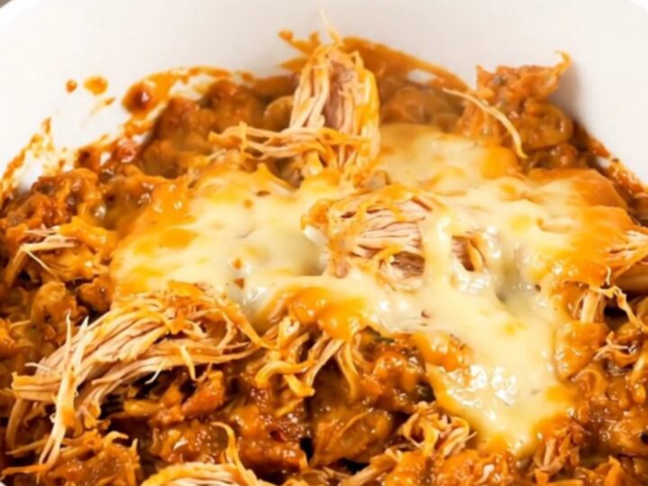 A top-down view of chicken and sweet potatoes in a slow cooker with a creamy sauce.