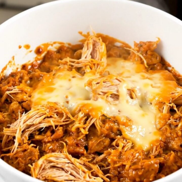 A top-down view of chicken and sweet potatoes in a slow cooker with a creamy sauce.