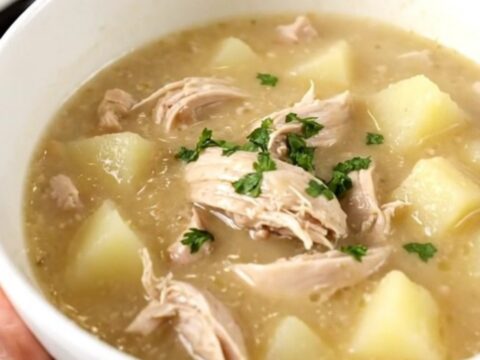 A steaming bowl of creamy chicken chowder filled with diced chicken and potatoes.
