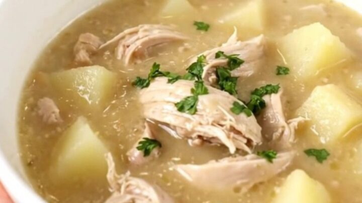 A steaming bowl of creamy chicken chowder filled with diced chicken and potatoes.
