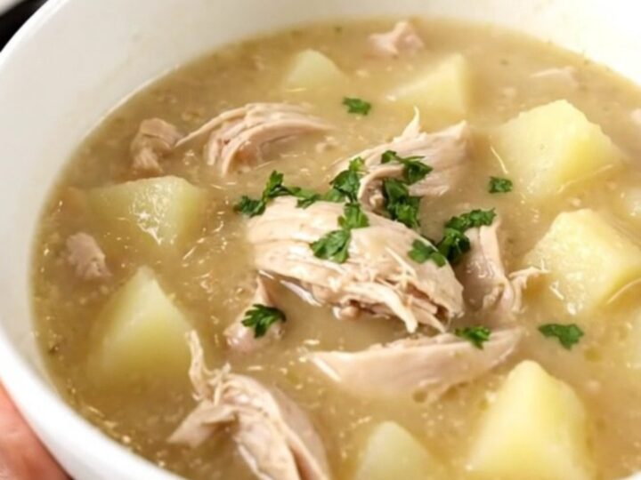 A steaming bowl of creamy chicken chowder filled with diced chicken and potatoes.
